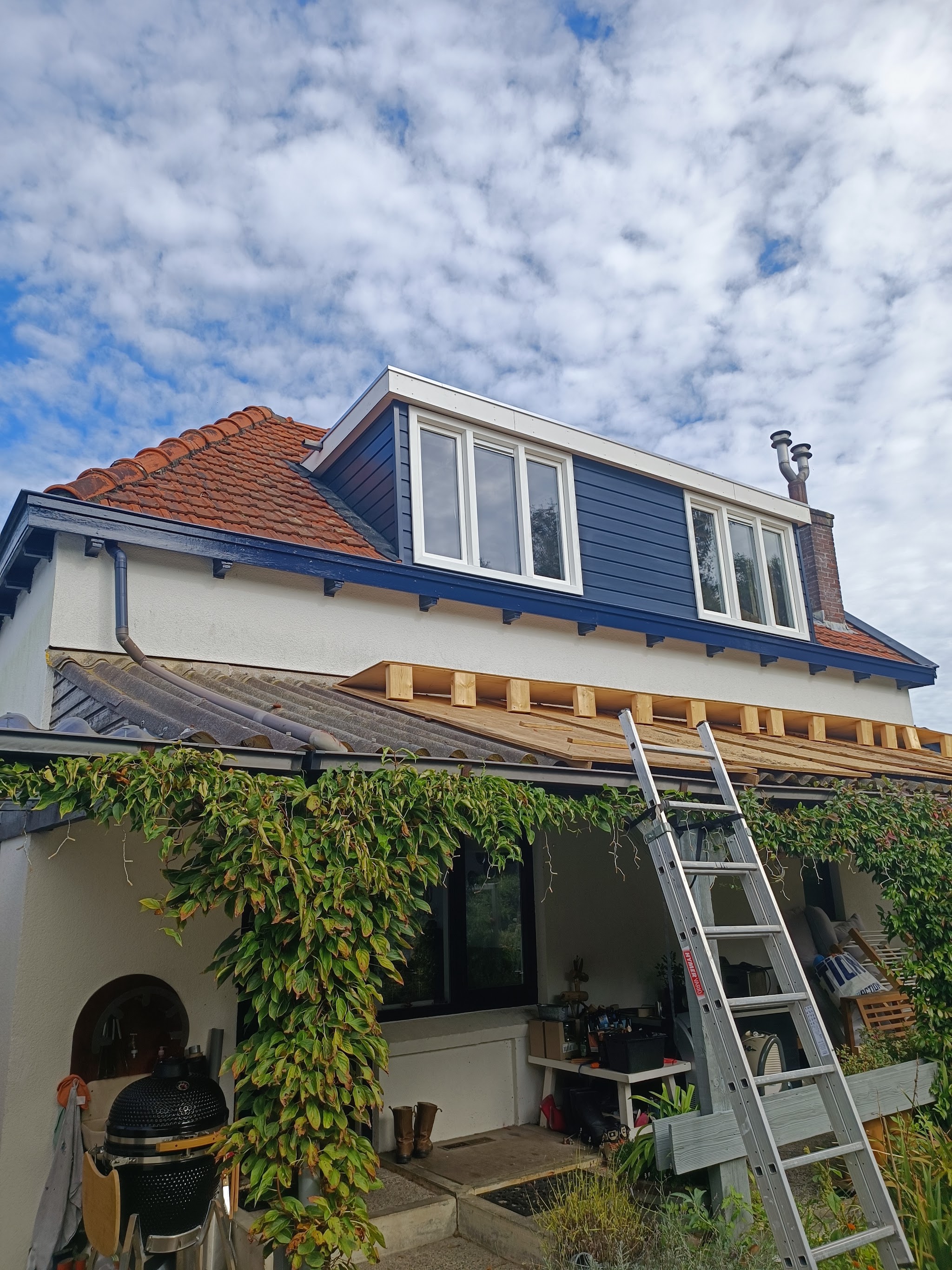 De nieuwe blauwe dakkapel aan de achterkant van het huis